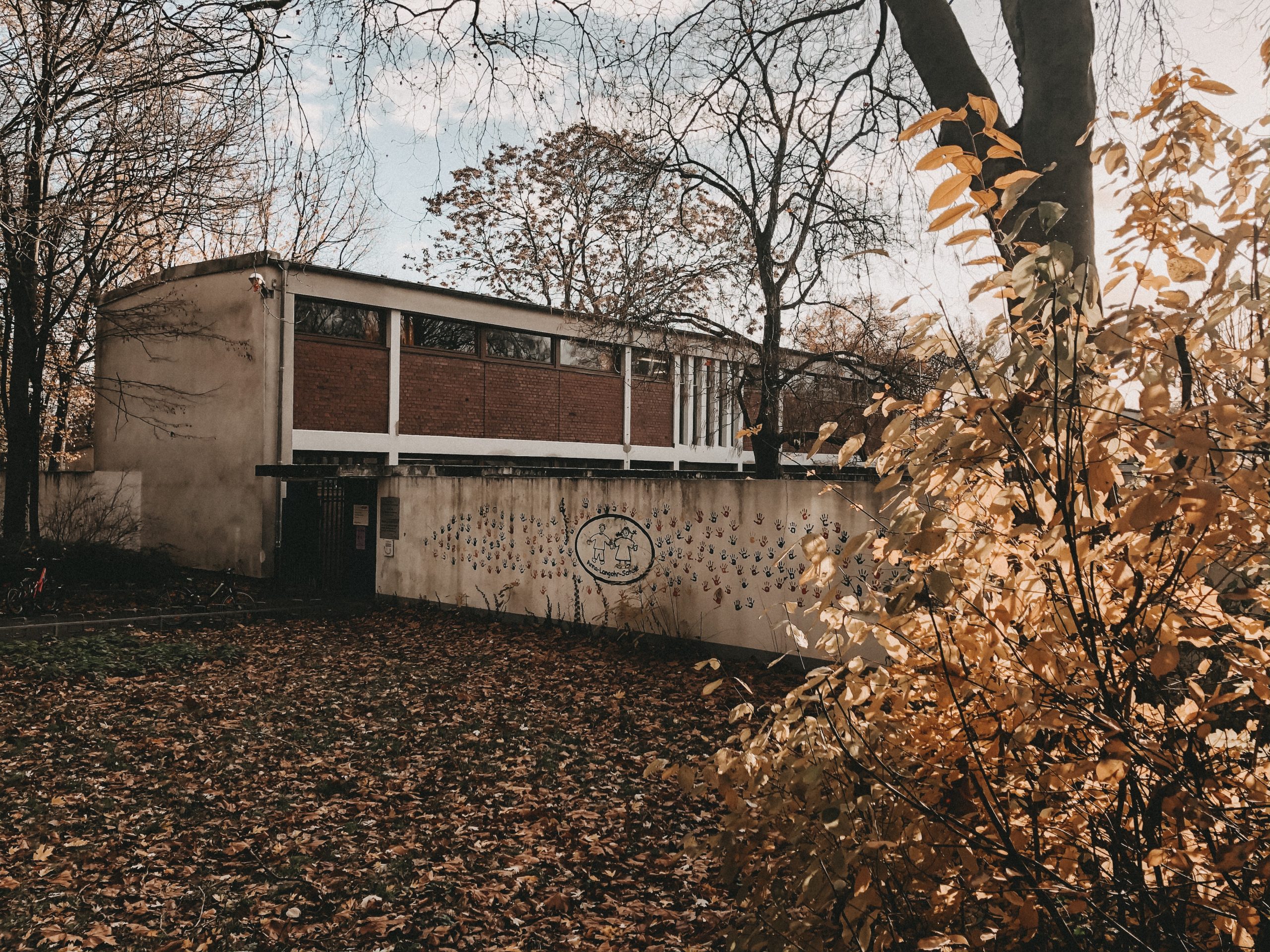 Das frühere Schulgebäude mit gemaltem Schullogo und bunten Handabdrücken