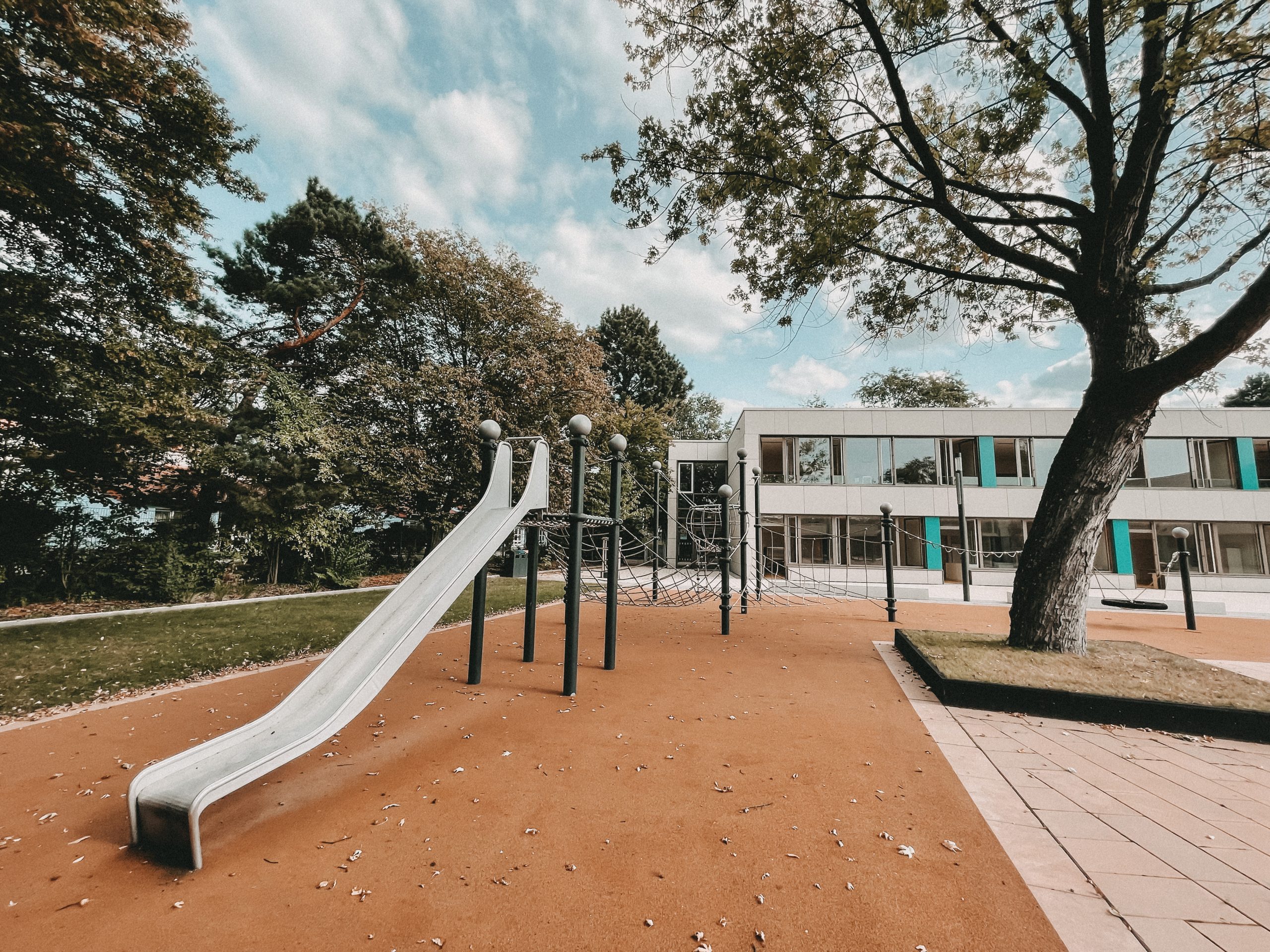 Spielplatz mit Rutsche und Klettergerüst auf dem Schulhof